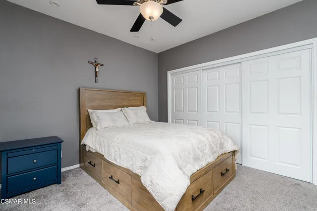 a bedroom with a bed and a ceiling fan