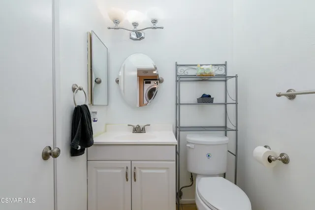 a bathroom with a toilet a sink and mirror