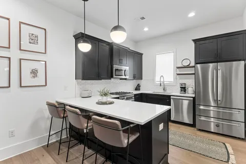 a kitchen with a table chairs refrigerator and microwave