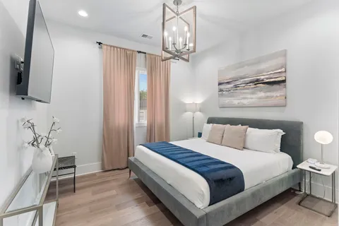 a spacious bedroom with a bed and a chandelier
