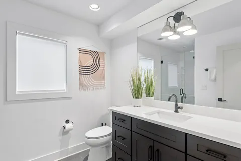 a bathroom with a sink a toilet and a mirror