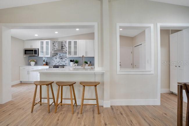 1926 Natalen Road Winter Park, FL 32792 - Photo 12 of 44 a kitchen with stainless steel appliances kitchen island granite countertop a wooden floor and white cabinets