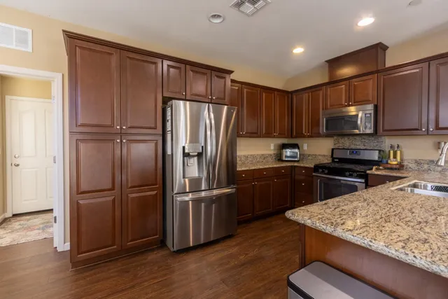 a kitchen with stainless steel appliances wooden floor sink and microwave