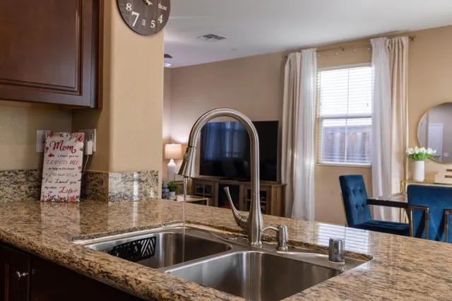 a kitchen with granite countertop wooden cabinets and a sink