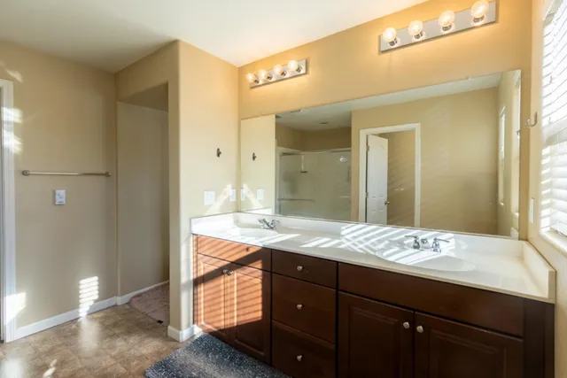 a bathroom with a glass shower door and a sink