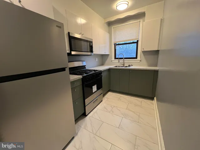 a kitchen with stainless steel appliances a refrigerator sink and microwave