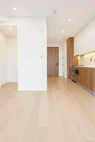 an empty room with a cabinet and mirrors