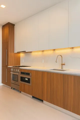 a kitchen with stainless steel appliances a sink stove and cabinets