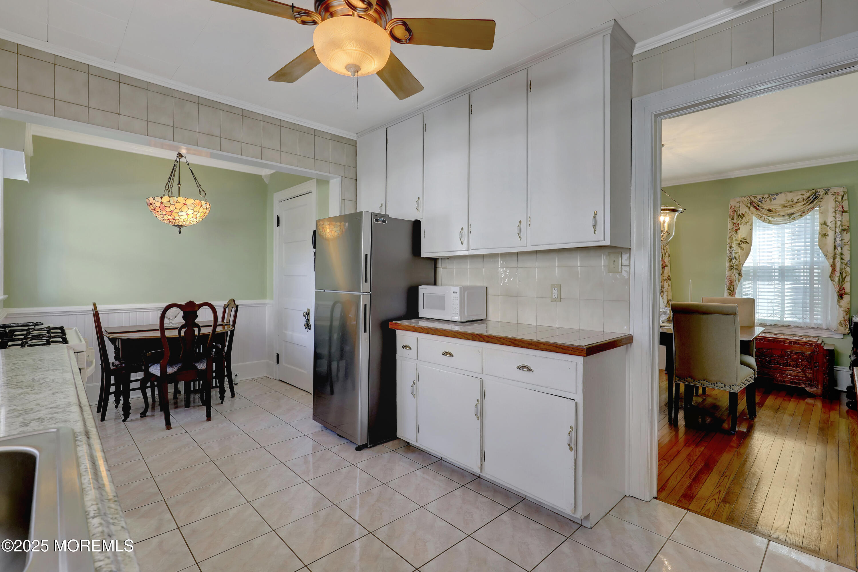 309 Spier Avenue Allenhurst, NJ 07711 - Photo 14 of 32 a kitchen with stainless steel appliances granite countertop a refrigerator a sink a dining table and chairs with wooden floor