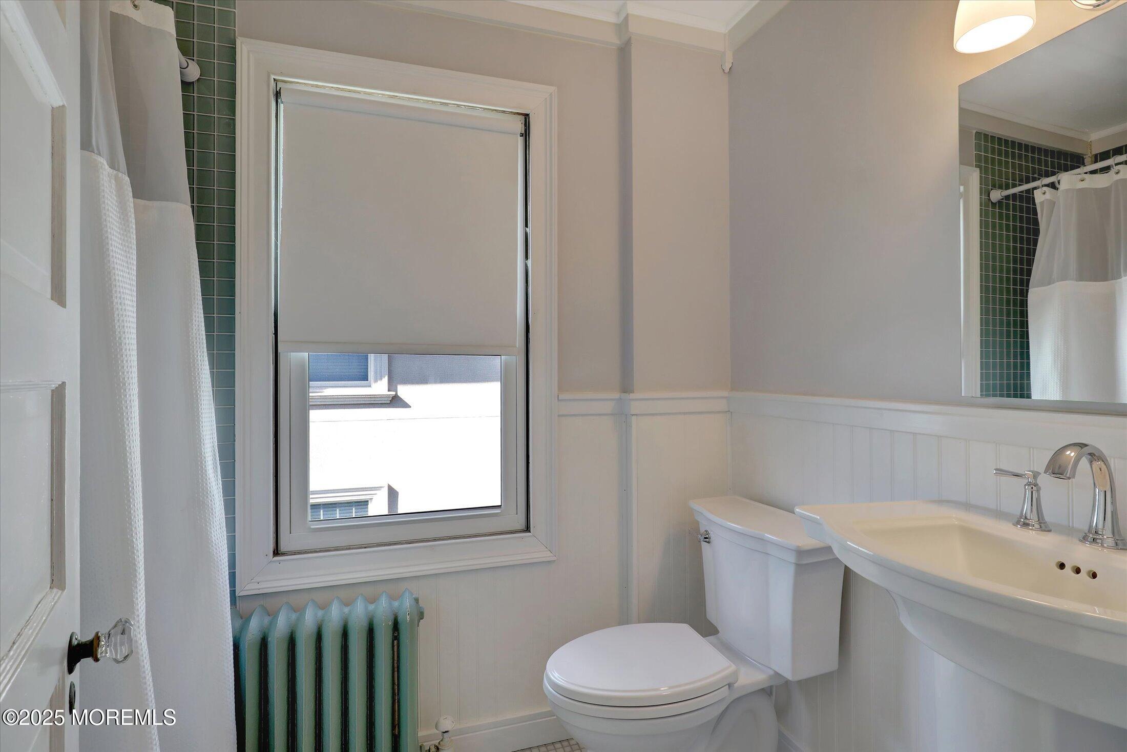309 Spier Avenue Allenhurst, NJ 07711 - Photo 24 of 32 a bathroom with a toilet a sink a mirror and vanity