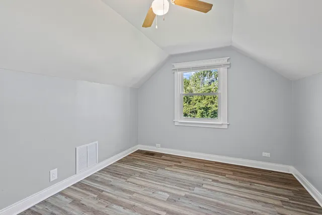 a view of a livingroom with wooden floor and a ceiling fan