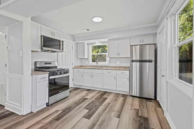 a kitchen with white cabinets and stainless steel appliances