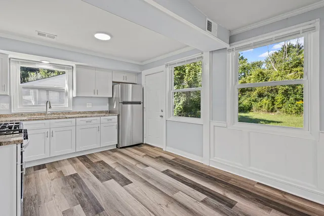 a kitchen with a sink window and cabinets