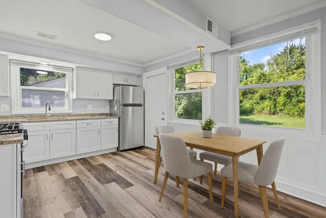 a kitchen with a table chairs refrigerator and cabinets