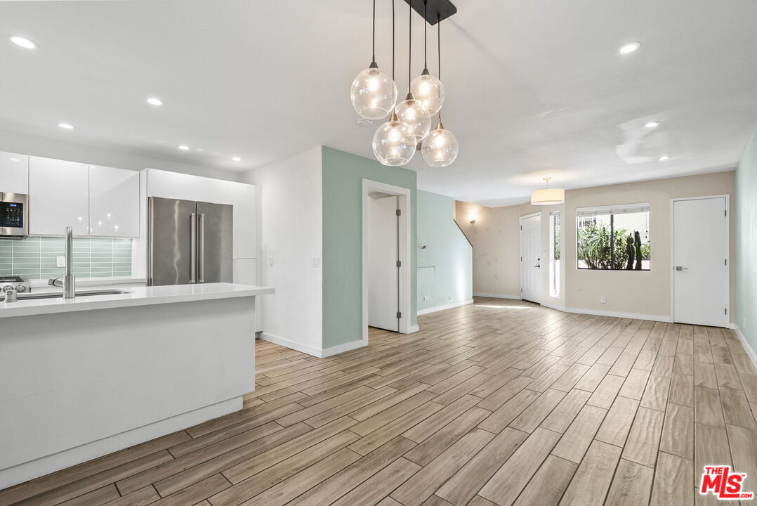 a view of a kitchen with wooden floor and a chandelier