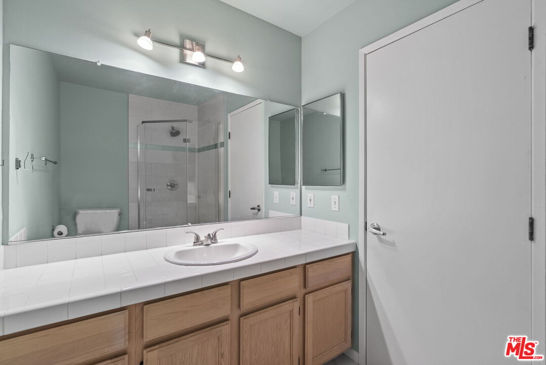 1802 20th Street, Unit B Santa Monica, CA 90404 - Photo 20 of 22 a bathroom with a sink a light fixture a vanity and a mirror