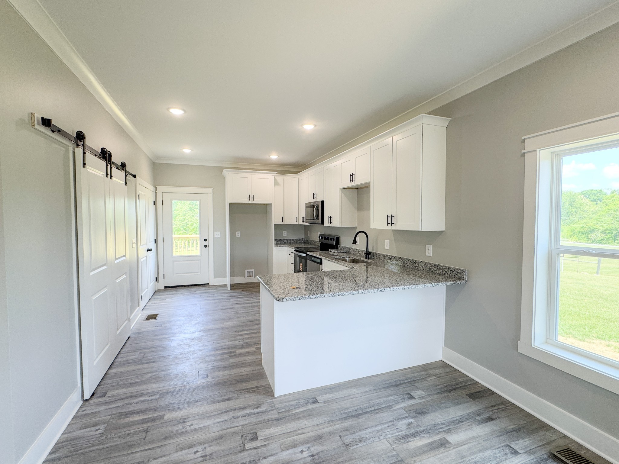 181 Rock House Hollow Road Bethpage, TN 37022 - Photo 17 of 51 a view of a kitchen with a sink wooden floor and a window