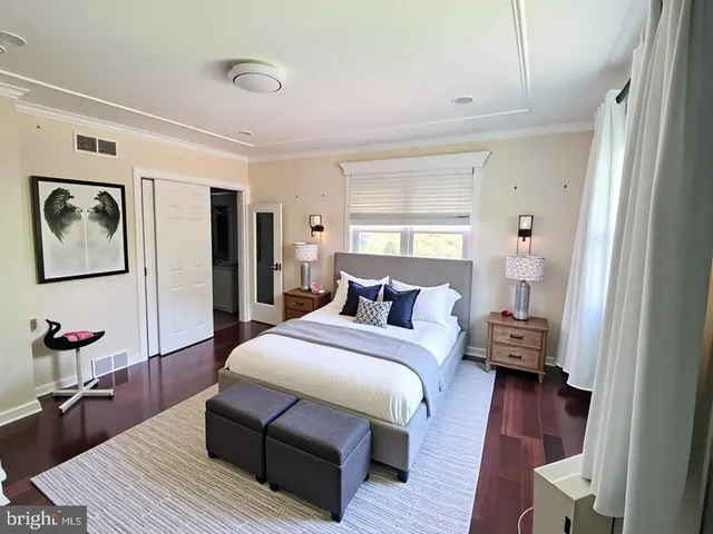 a bedroom with a bed wooden floor and a window