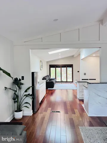 a large white kitchen with wooden floors