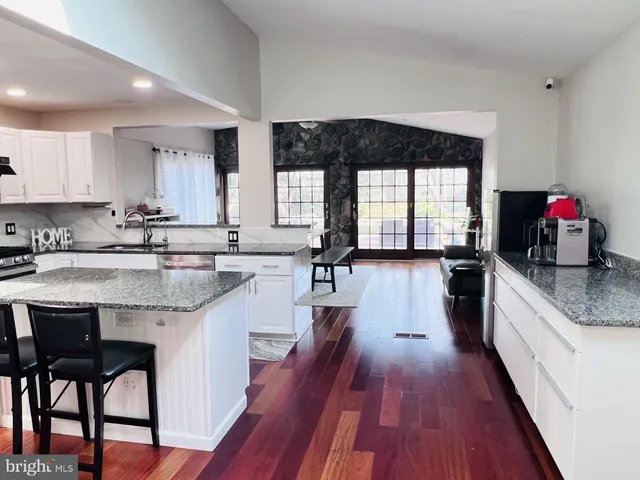 a kitchen with granite countertop wooden floors and white appliances