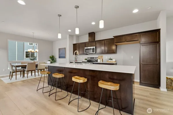 a kitchen with stainless steel appliances granite countertop a sink a stove and a refrigerator