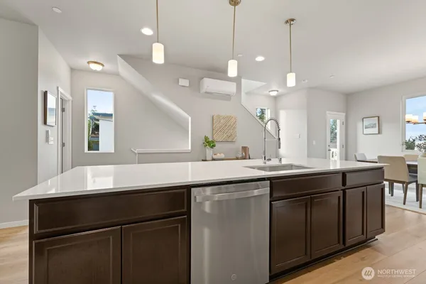 a kitchen with kitchen island granite countertop a sink a counter space appliances and cabinets