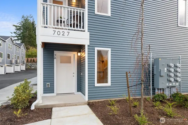 a view of a hallway with wooden floor and a bathroom