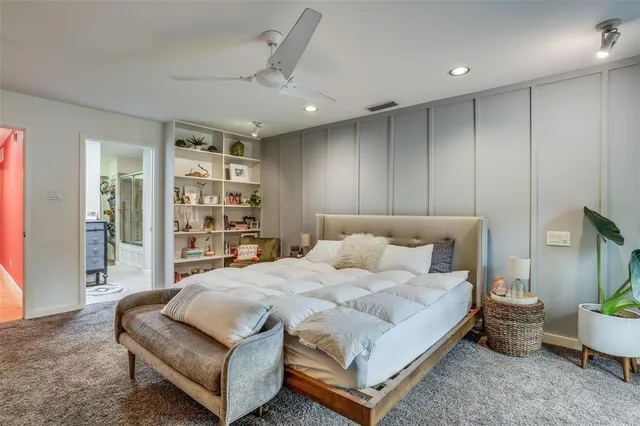 a bedroom with a large bed and a potted plant