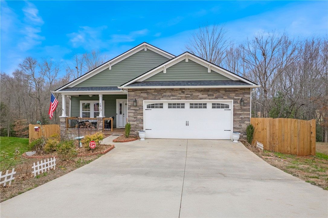 This charming home features a lovely front porch and a spacious driveway.