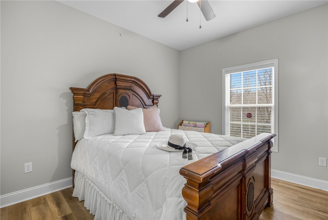 28 Vanessa Rae Lane Pendleton, SC 29670 - Photo 11 of 16 This inviting bedroom features rich wooden flooring and a bright window, creating a serene personal retreat.