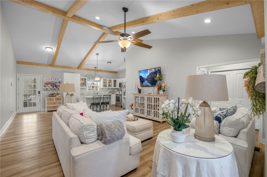 28 Vanessa Rae Lane Pendleton, SC 29670 - Photo 16 of 16 This bright living area features an open floor plan with vaulted beamed ceilings and hardwood flooring.