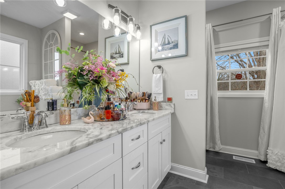 28 Vanessa Rae Lane Pendleton, SC 29670 - Photo 7 of 16 This primary bathroom features a double vanity with marble countertops and sleek tile flooring.