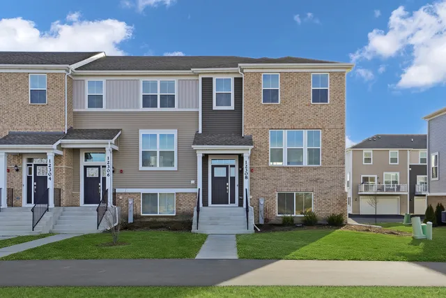 a front view of a brick house with a yard