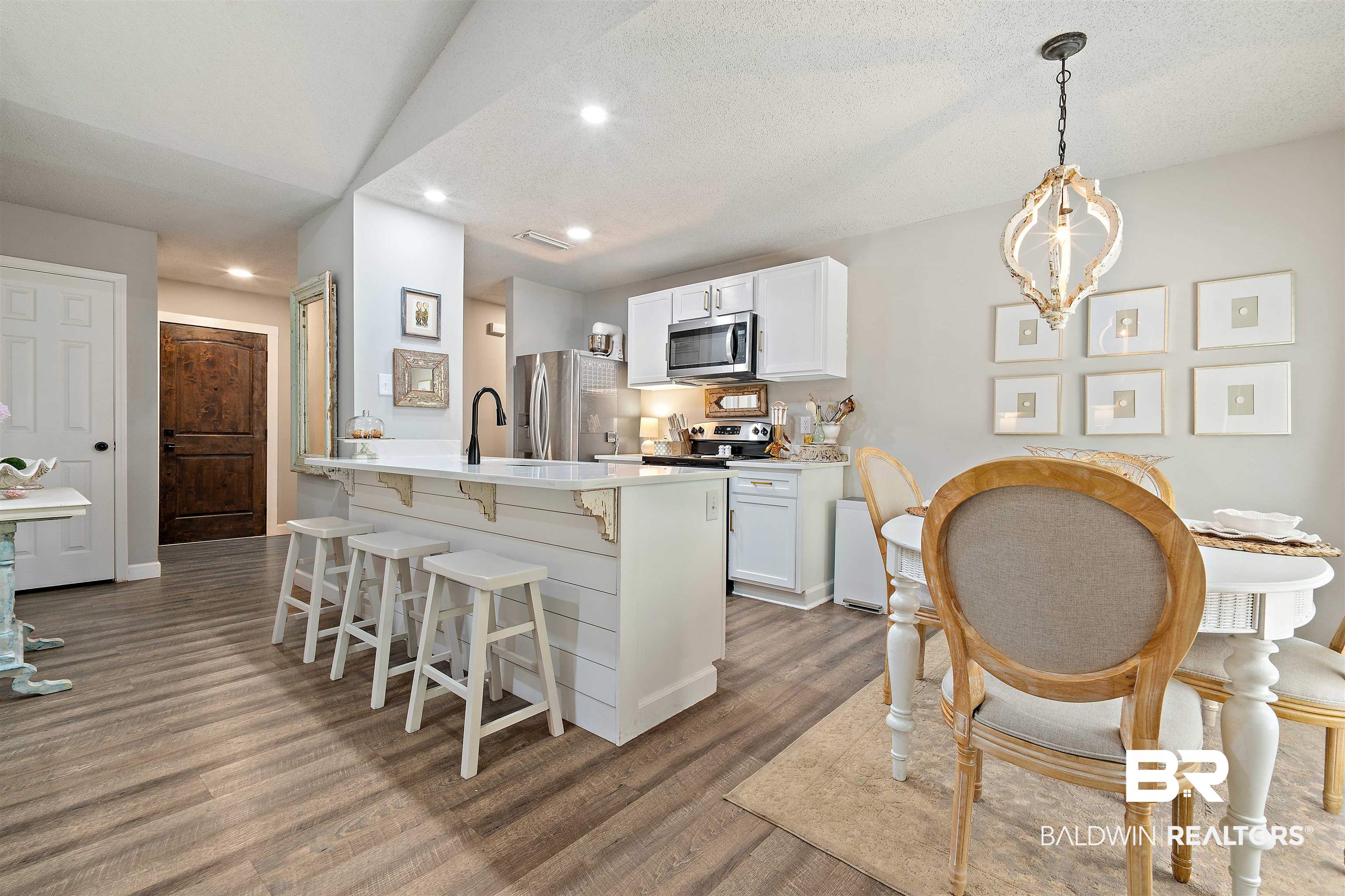 4682 Opal Drive Mobile, AL 36619 - Photo 7 of 27 Kitchen featuring hanging light fixtures, hardwood / wood-style floors, white cabinets, and appliances with stainless steel finishes