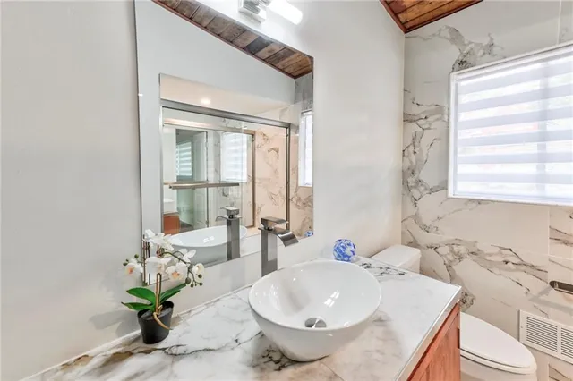 a bathroom with a bathtub shower sink and mirror