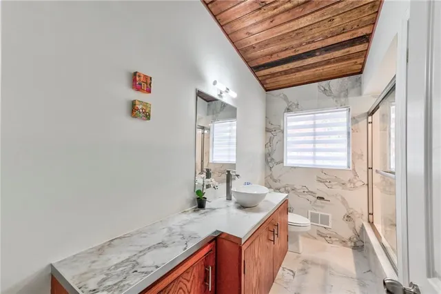 a bathroom with a sink a toilet and shower