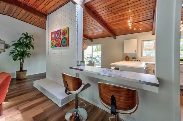 a kitchen with a table chairs refrigerator and a potted plant