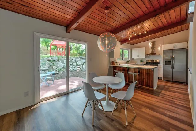 a dining room with furniture a rug a chandelier and wooden floor