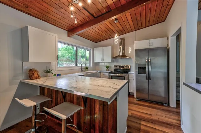 a kitchen with a table chairs refrigerator and cabinets