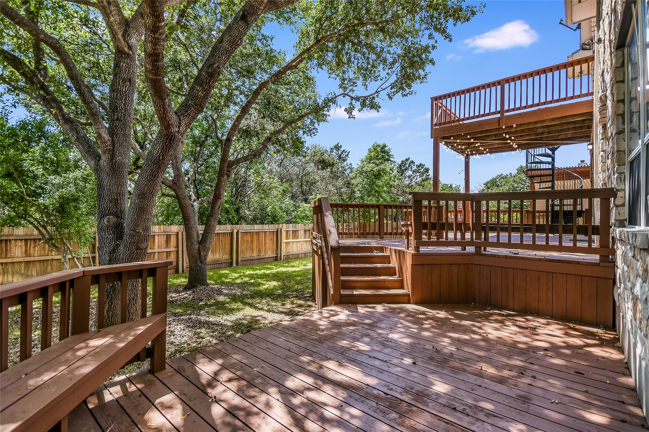 12935 Brigham Drive Austin, TX 78732 - Photo 2 of 35 Enjoy seamless indoor-outdoor living with backyard decks that overlook the serene greenbelt, creating an ideal space for entertaining friends and family.