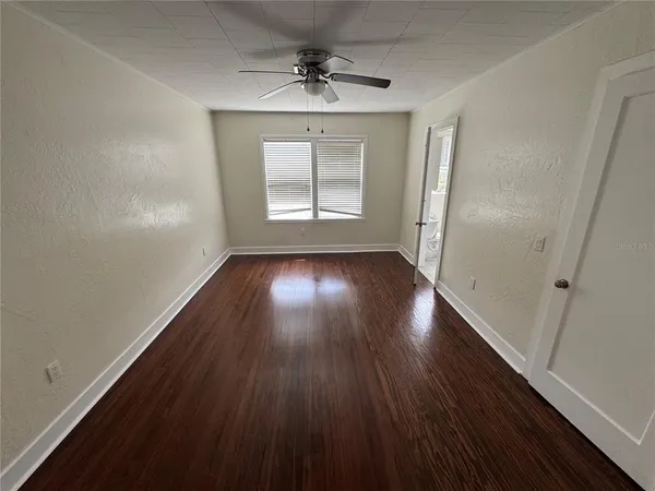wooden floor in an empty room with a window