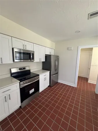 a kitchen with stainless steel appliances a stove a sink and a refrigerator