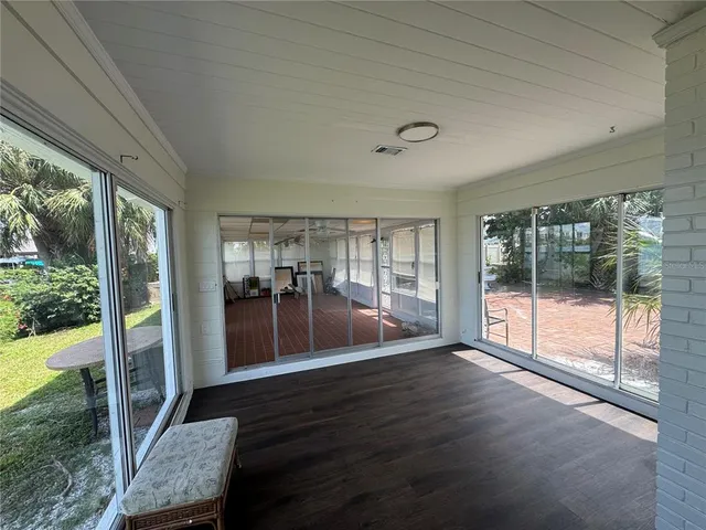 a living room with hardwood floor and a floor to ceiling window