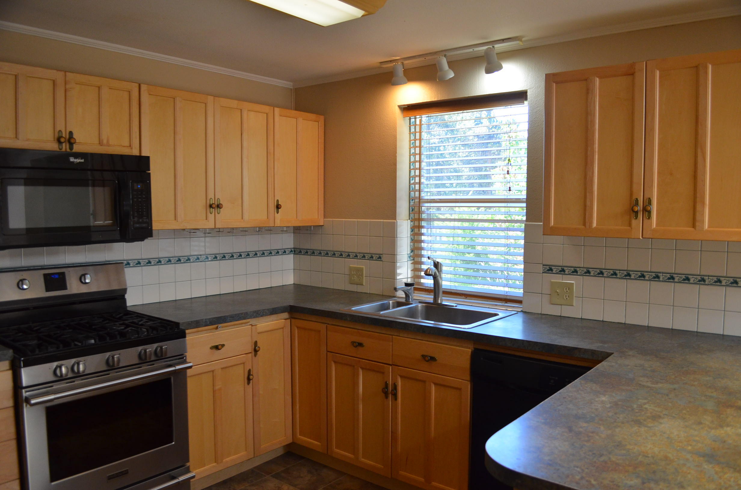 137008 Main Street Crescent, OR 97733 - Photo 8 of 50 a kitchen with granite countertop cabinets stainless steel appliances a sink and a window