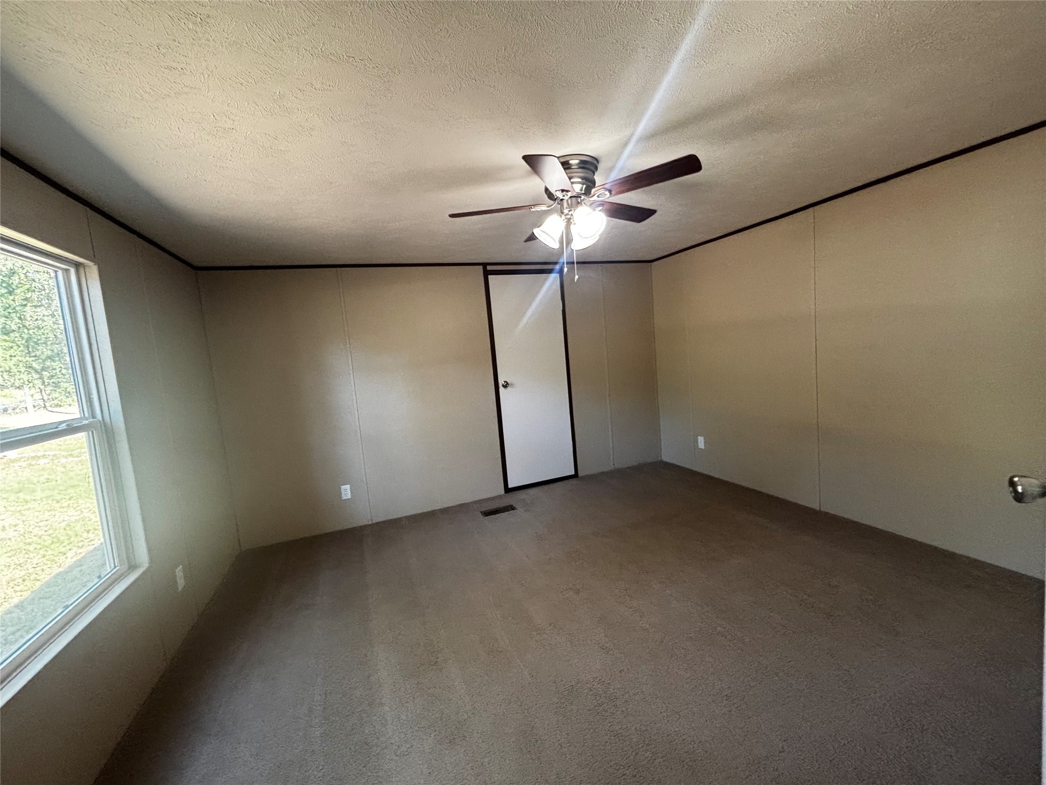 10 South Walnut Lake Drive Huntsville, TX 77320 - Photo 5 of 12 an empty room with windows and fan