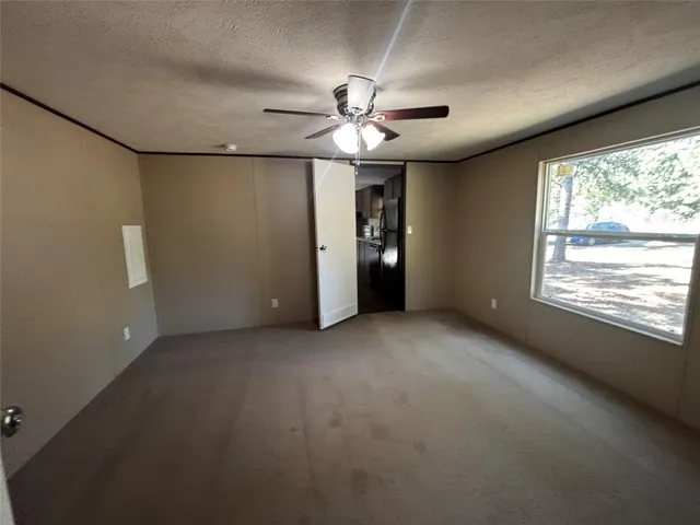 an empty room with a ceiling fan and a window