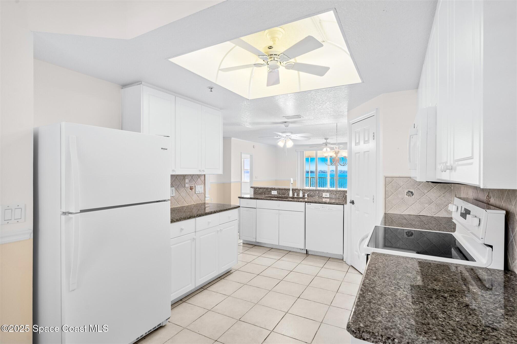 104 Riverside Drive, Unit 402 Cocoa, FL 32922 - Photo 11 of 41 a kitchen with white cabinets and white appliances