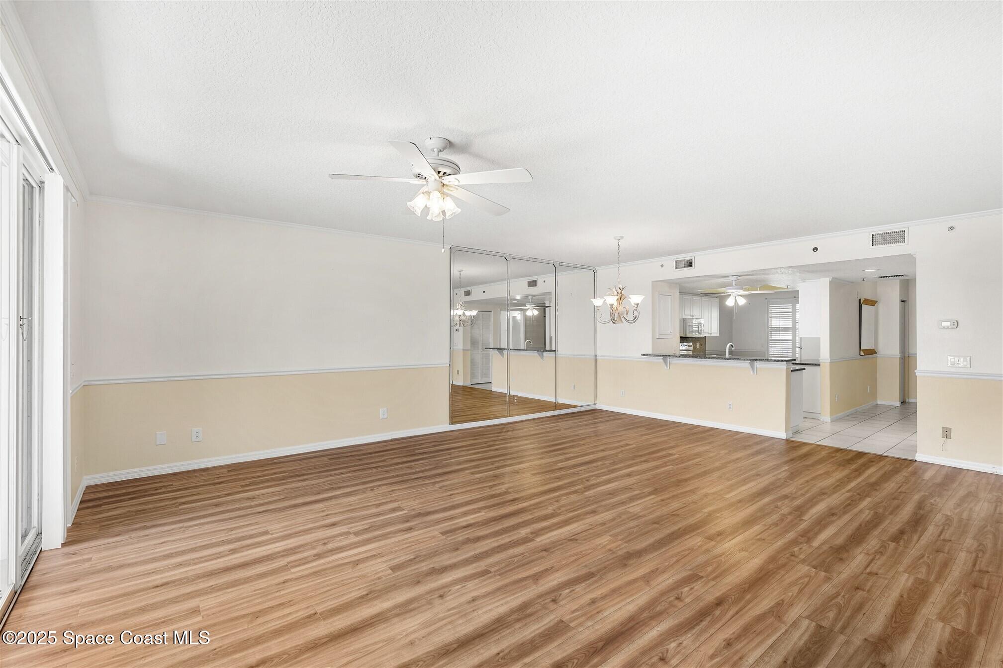 104 Riverside Drive, Unit 402 Cocoa, FL 32922 - Photo 12 of 41 an empty room with wooden floor and windows