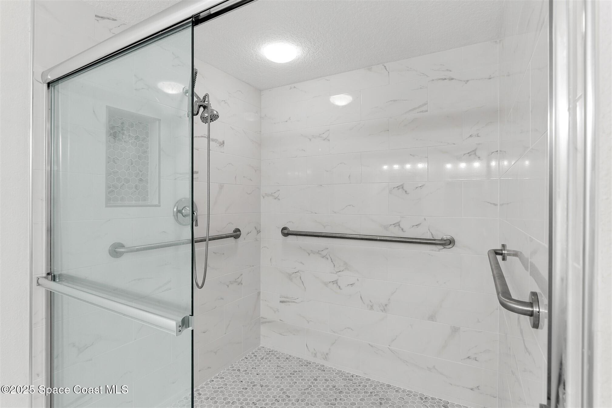 104 Riverside Drive, Unit 402 Cocoa, FL 32922 - Photo 18 of 41 a bathroom with a shower and a glass door