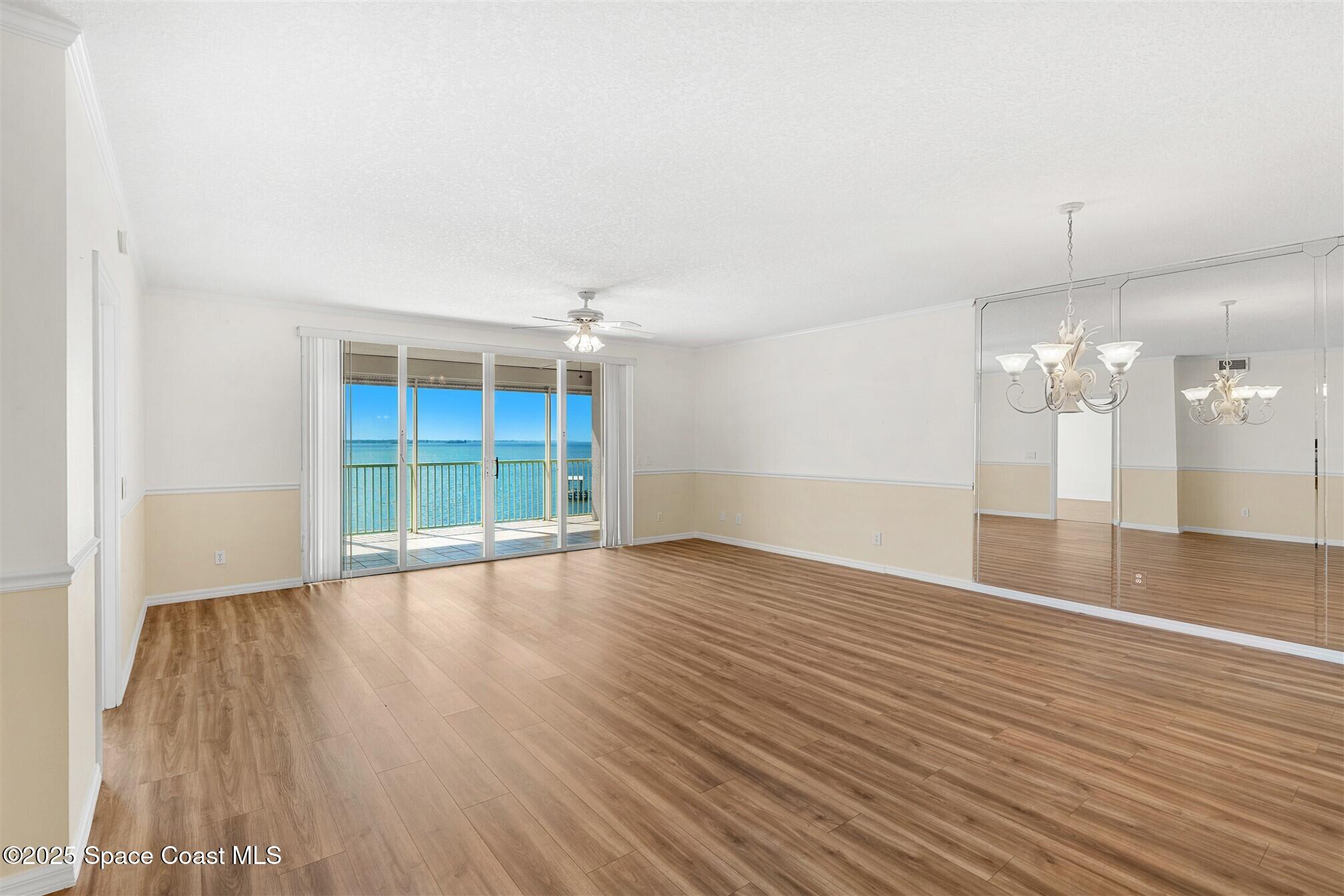 104 Riverside Drive, Unit 402 Cocoa, FL 32922 - Photo 2 of 41 an empty room with wooden floor and windows